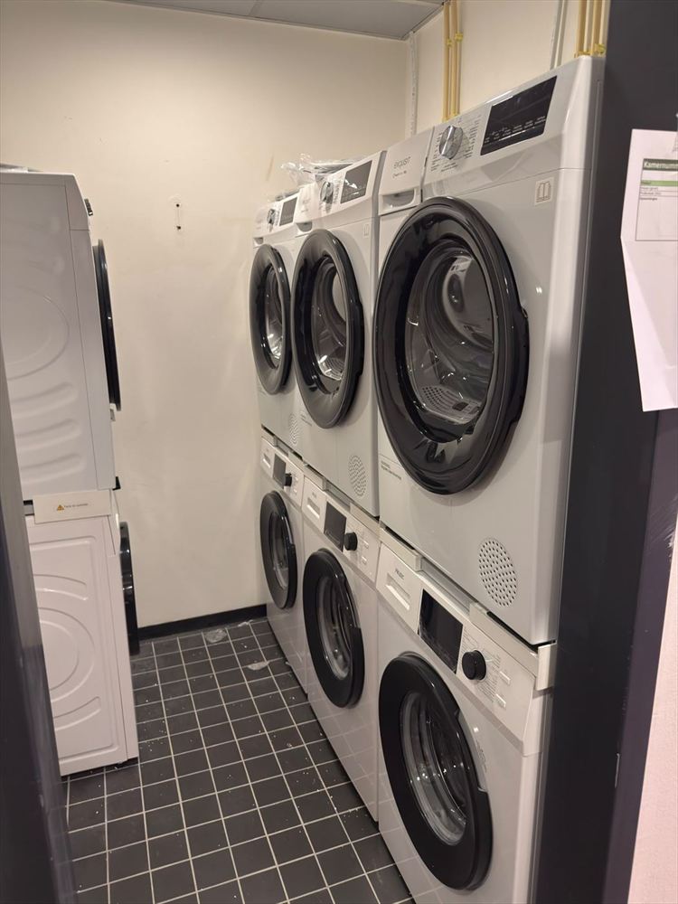 Washing machines and dryers stacked in a shared laundry room