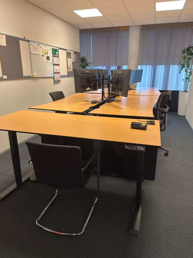 Office room with desks, monitor arms and chairs set out